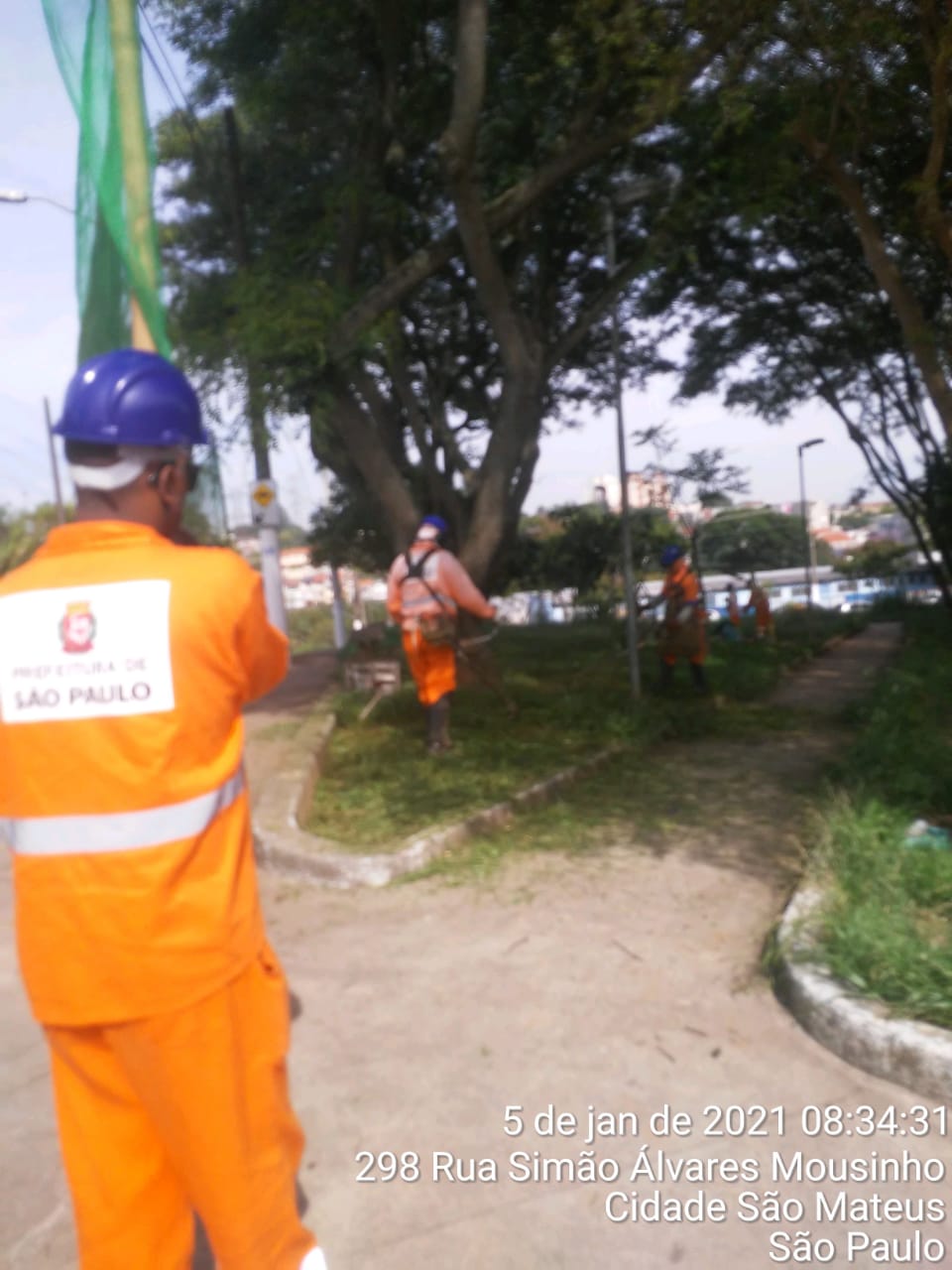 Homens trabalham no corte de grama e limpeza, na rua Simão Álvares Mousinho
